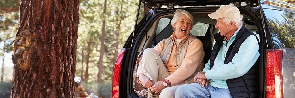 An older couple takes a break during a road trip.