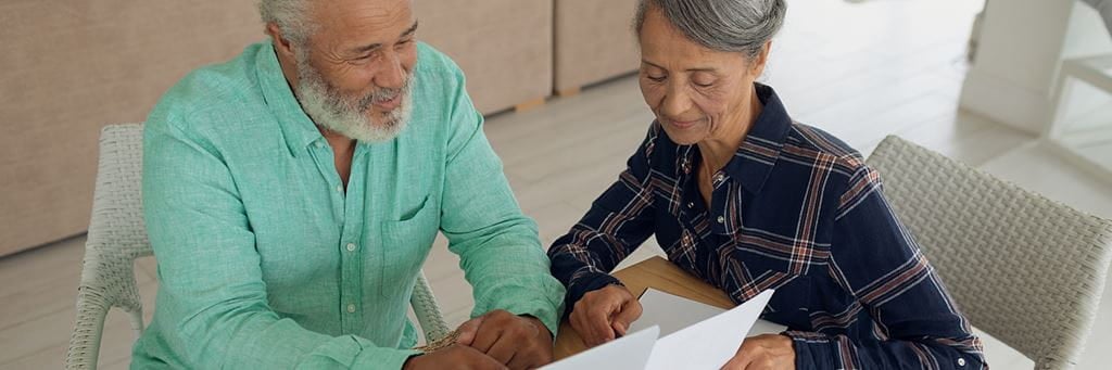 A retired couple reviews financial documents before filing taxes for Tax Day 2021.