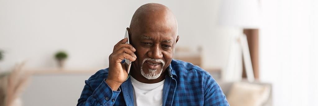 An older man talks on the phone.