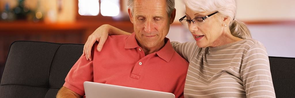 A senior couple uses a laptop while estate planning for digital assets.
