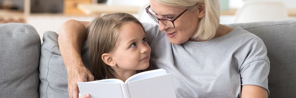 A grandmother reads to her granddaughter.