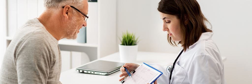 A doctor and patient review an Advance Beneficiary Notice of Noncoverage together.