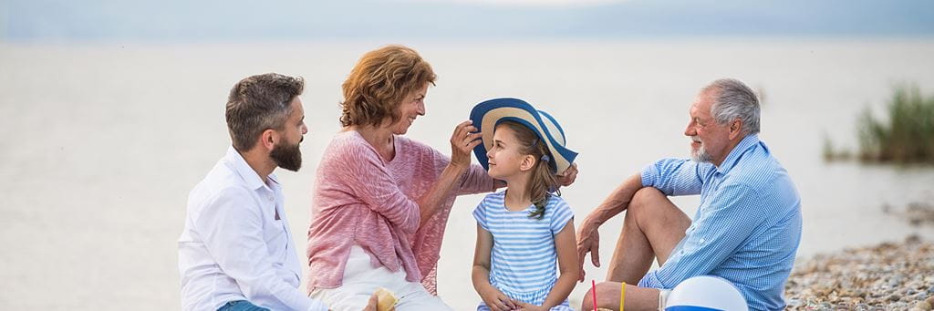 A multigenerational family enjoys a day at the beach.