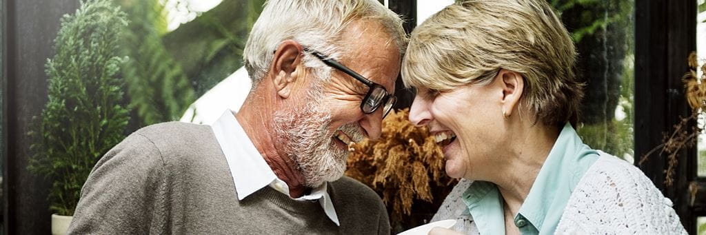 An older couple smiles at each other.
