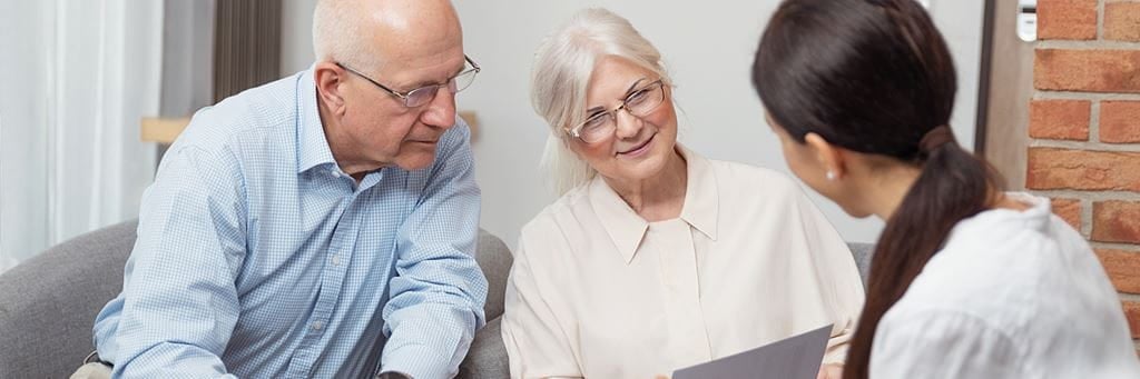 A senior couple reviews documents to decide when to start collecting Social Security benefits.