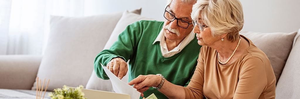 A senior couple discusses their finances and VA loan options.