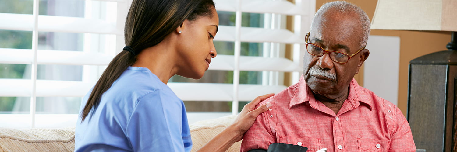 A nurse taking a senior man's blood pressure in a nursing home.
