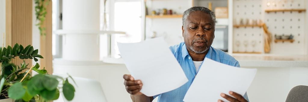 A senior man looks at Medicare bills.