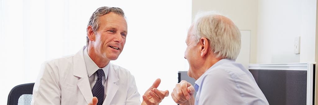 A senior patient talks with a doctor.