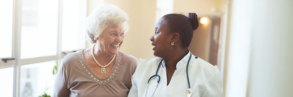 A senior woman talks with a doctor.
