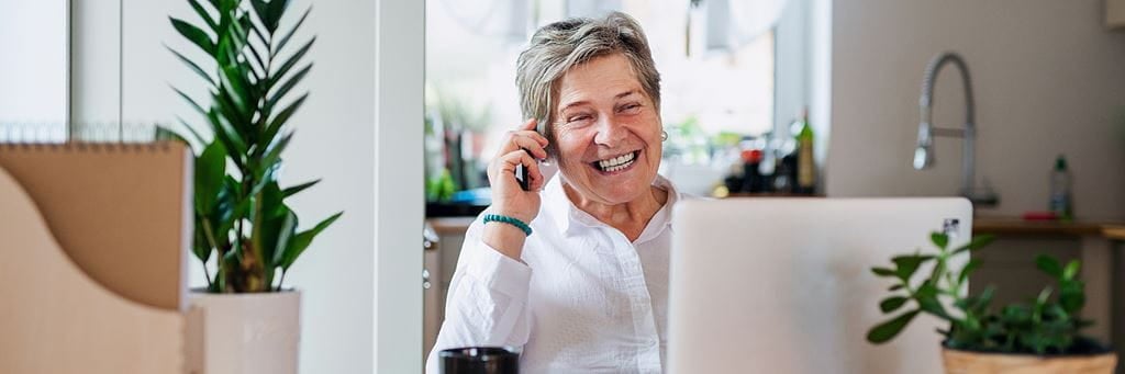 A self-employed woman talks on the phone about her retirement planning.