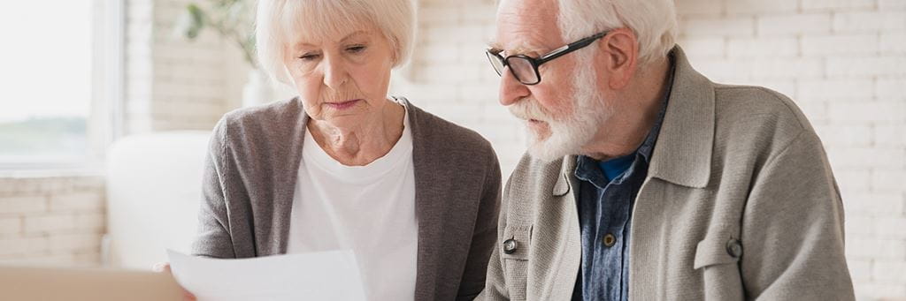 An older couple reviews a life insurance contract.