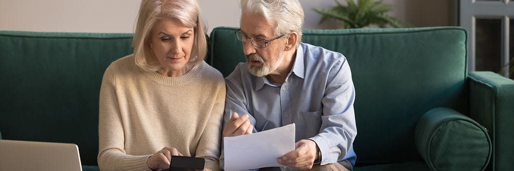 A couple reviews financial documents while planning for retirement.