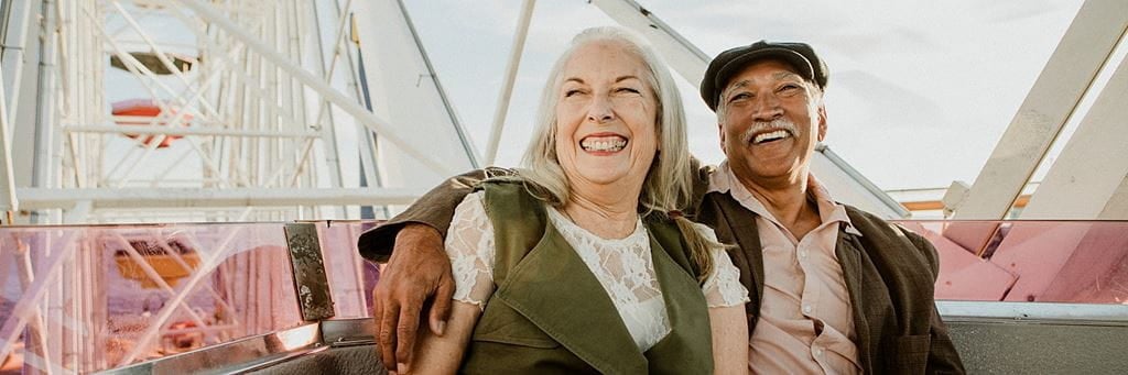 A smiling senior couple on a Ferris wheel.