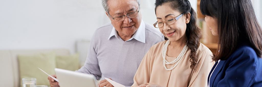 A senior couple discusses long-term care insurance options with an advisor.