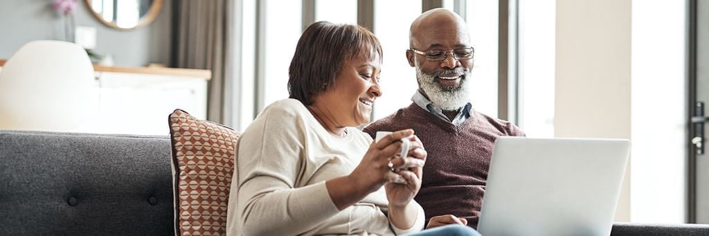 Man and woman looking at Medicare options on a computer.